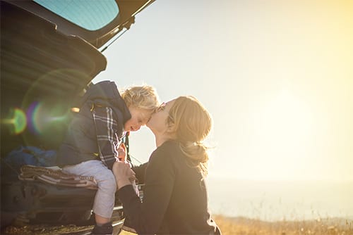 Woman with child in back of car